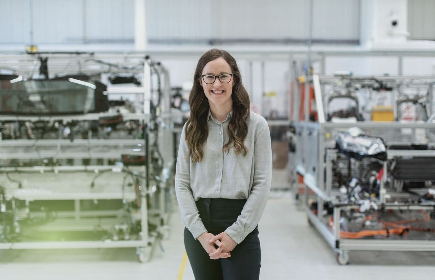 A smiling engineer standing in a modern workshop